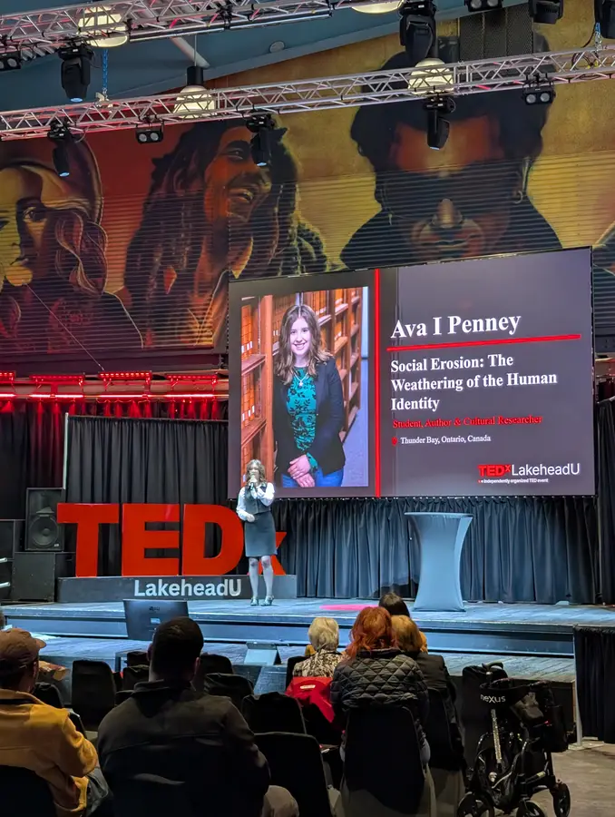 Ava I. Coyne on stage beside her title slide